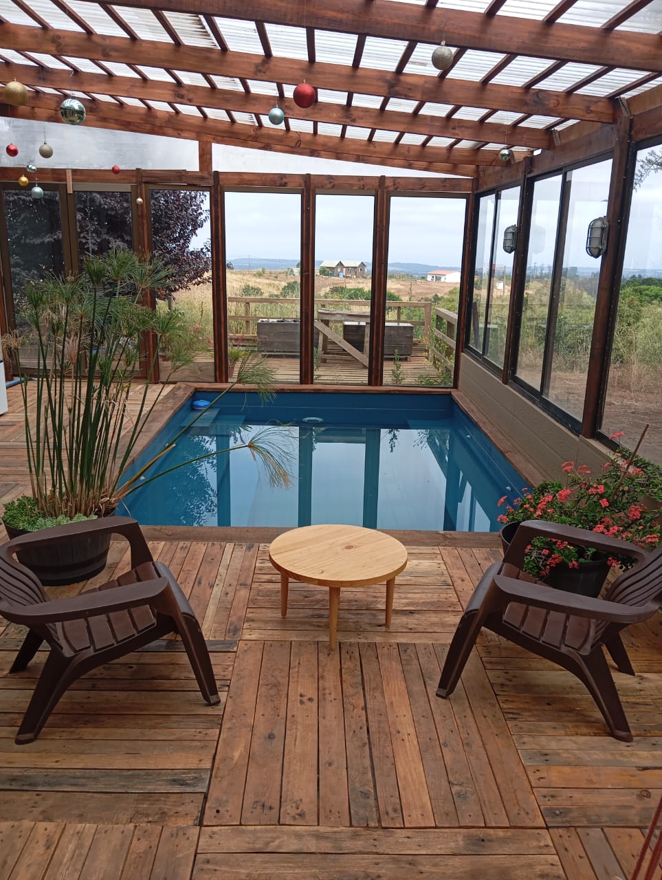 Terraza con piscina techada construida por Constructora Pilpilén